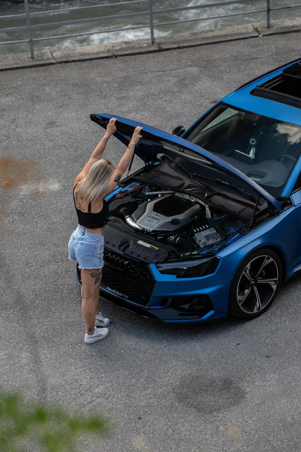 Vue plongeante sur une Audi RS5 bleue capot ouvert, moteur apparent