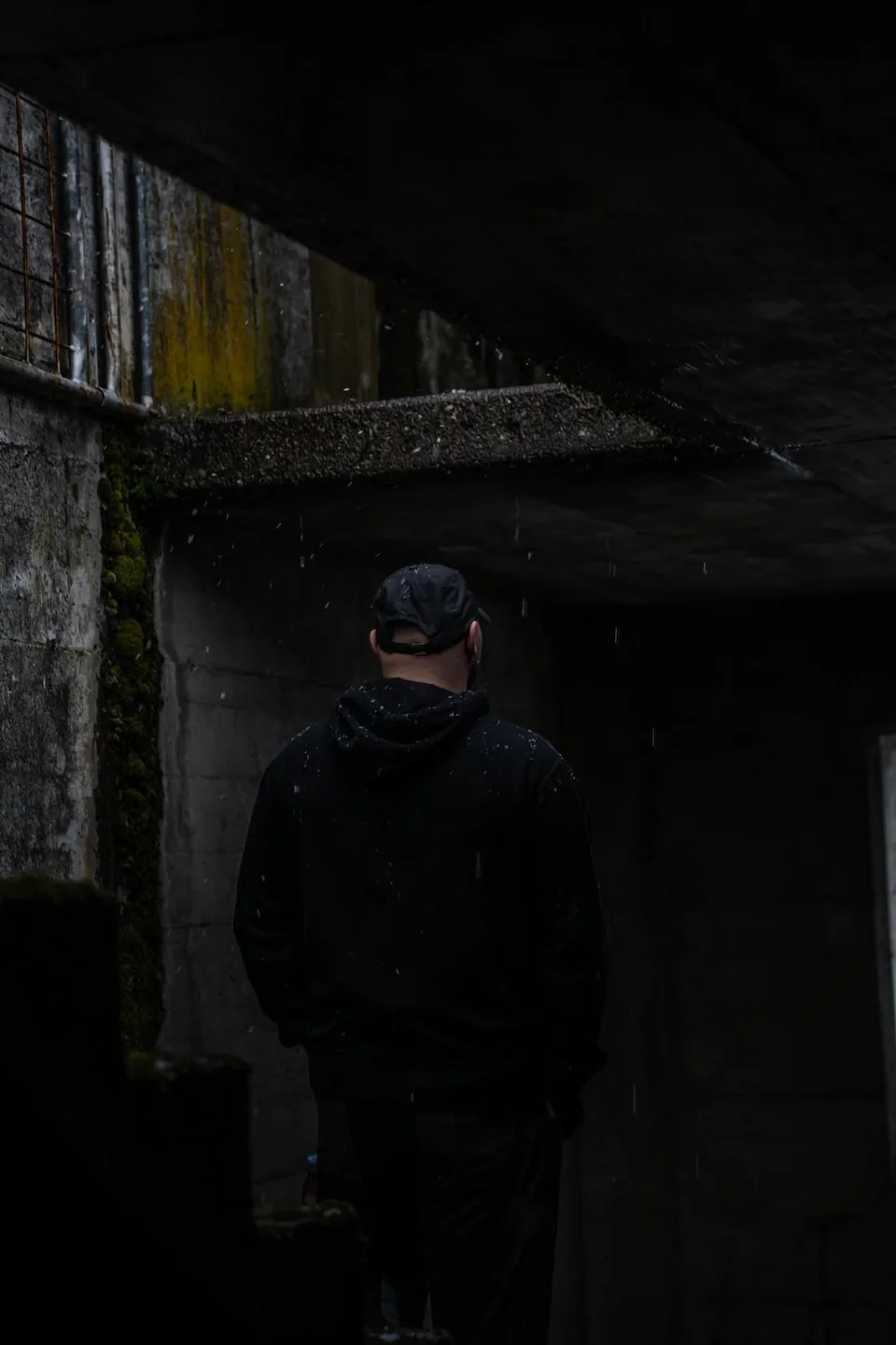 Silhouette d'un homme de dos dans une structure de béton sombre